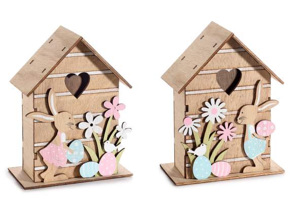 Casa de madera con conejo, flores y corazón tallado.
