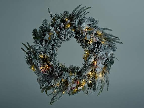 Snowy wreath with pine cones, red and white berries and LED