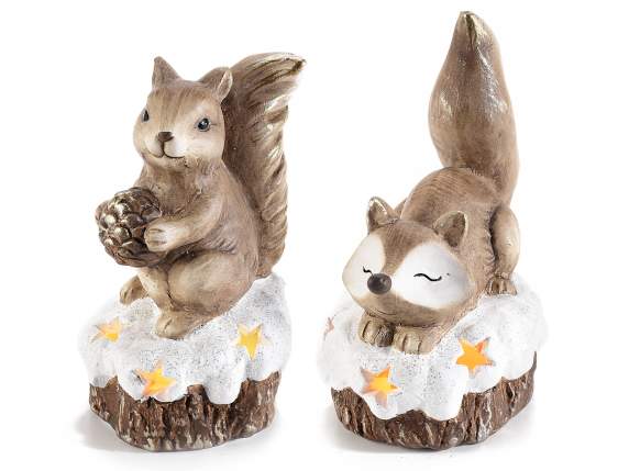 Terrakotta-Fuchs und Eichhörnchen auf einem verschneiten Sta