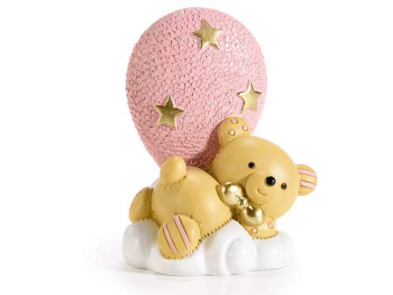 Teddybär liegt auf einer Wolke mit rosafarbenem Harzballon