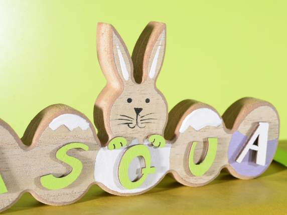 Pascua escrita en madera de colores con huevos y conejitos.