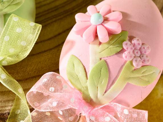 Egg with flowers and organza ribbon on wooden stick