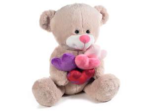 Sitting teddy bear with colorful stuffed hearts