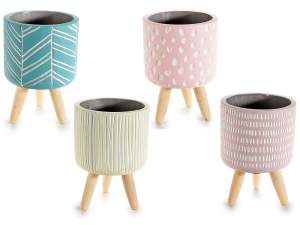 Colored and decorated concrete vase on wooden tripod