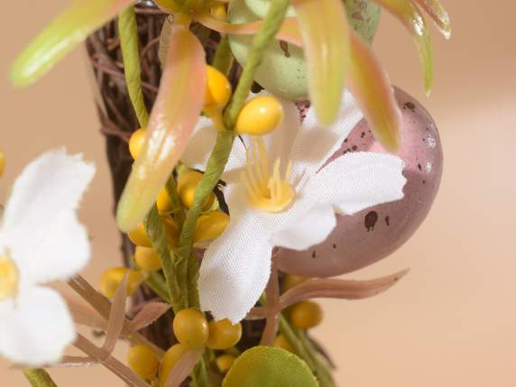 Guirnalda de huevos de colores con lazo de rafia y flores.