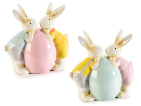 Conejitos de Pascua con huevo de cerámica de colores.