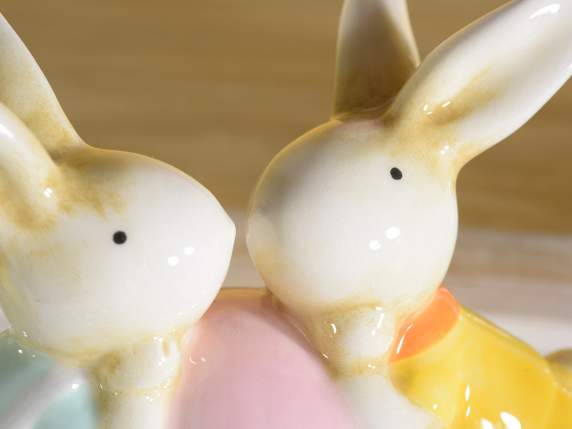 Conejitos de Pascua con huevo de cerámica de colores.