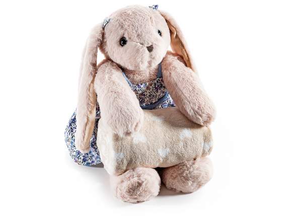 Conejito de peluche con vestido colorido y manta suave.