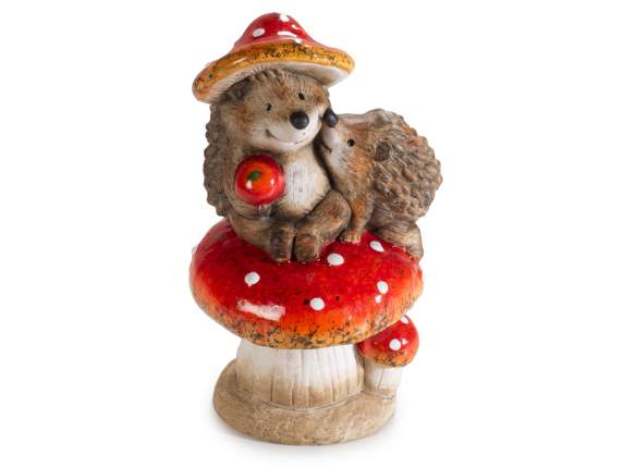 Des hérissons sembrassent sur un champignon en terre cuite