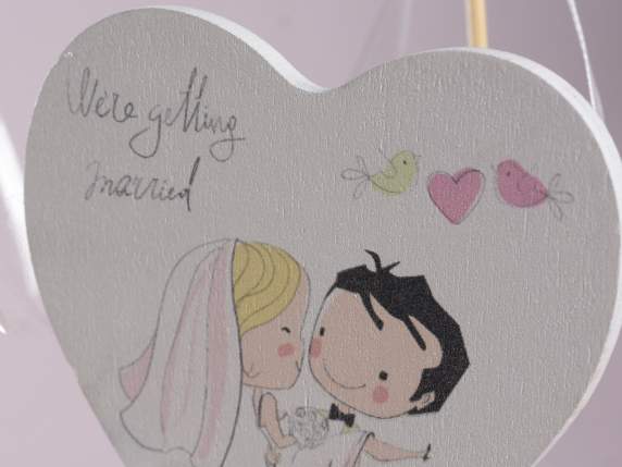 Coeur en bois sur bâton avec noeud et décorations de mariage