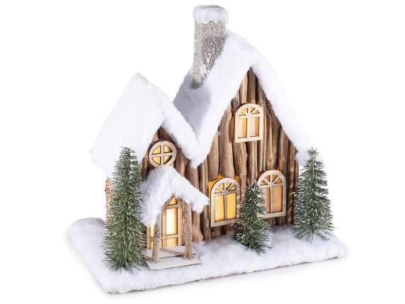 Casa de madera con capa de nieve y luces LED.