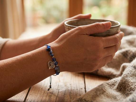 Pulsera de cuerda con piedras de colores y charm de metal.
