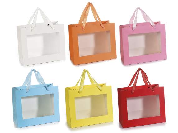 Sobre grande de papel de color con asas de tela y ventana.