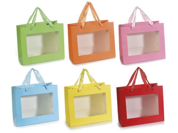 Sobre grande de papel de colores con asas de tela y ventana.