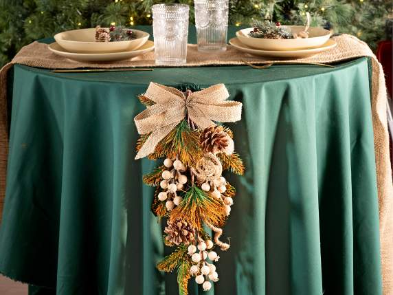 Corona colgante con piñas, bayas y lazo de yute.