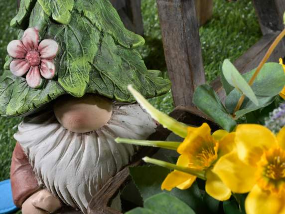 Gnome de magnésie avec chapeau de feuille et vase brouette