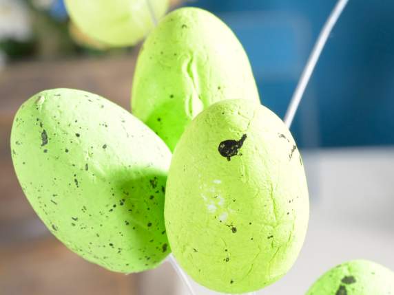 Wooden stick with colored eggs and feathers