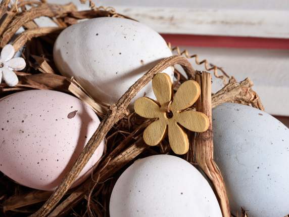 Wreath with colored eggs and wooden flowers