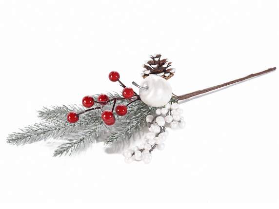 Snow-covered branch with pine cone, berries and apple