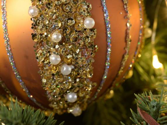 Glass ball with golden gems, pearls and glitter on display
