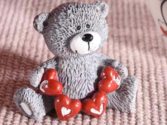 Sitting bear in colored resin with hearts to rest