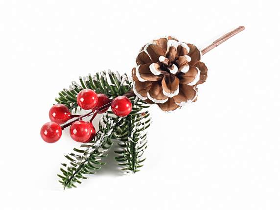 Pine branch with snow-covered pine cone and red berries