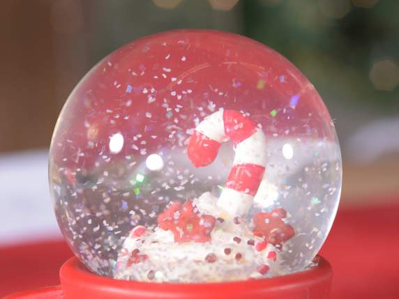 A cup of Christmas snow globe on decorated resin base