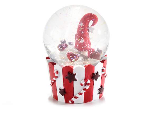A cup of Christmas snow globe on decorated resin base
