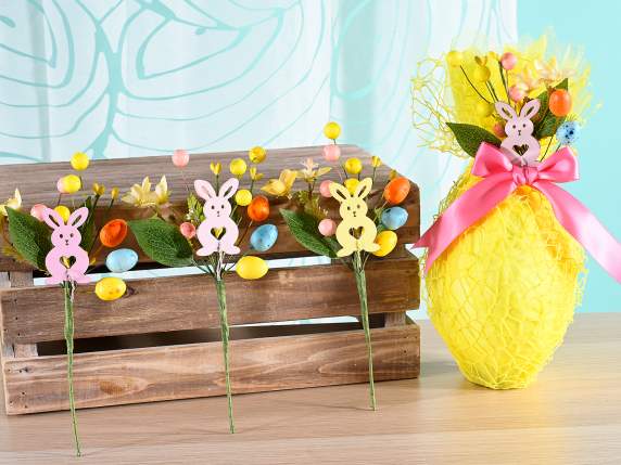 Bouquet doeufs colorés et de baies avec lapin en bois