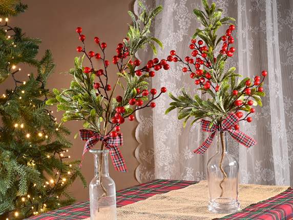 Red berry branch with snowy leaves and bow