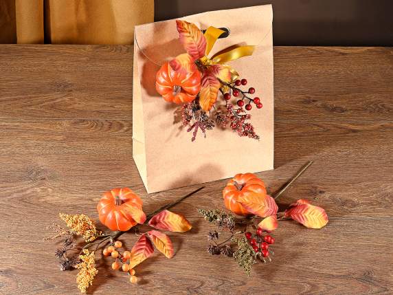 Branche avec citrouille artificielle, feuilles et baies