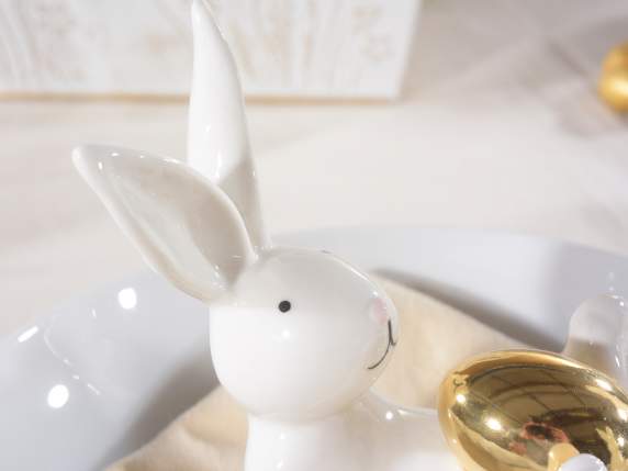 Lapin en céramique couché avec un œuf brillant ressemblant à