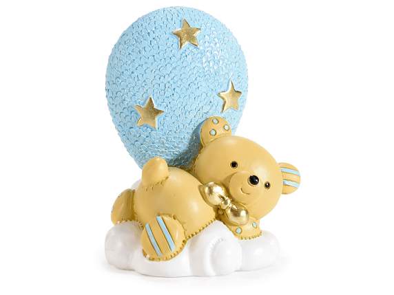 Teddy bear lying on a cloud with a blue resin balloon