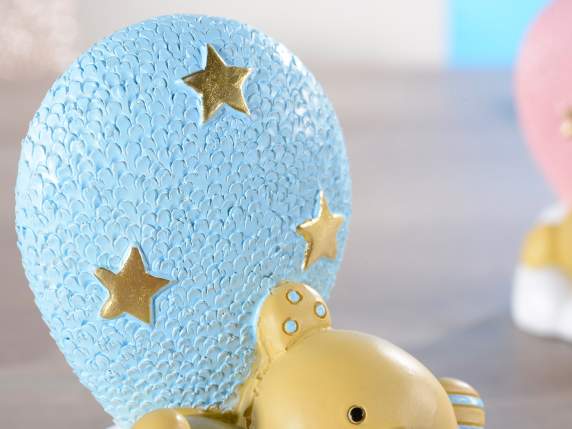 Teddy bear lying on a cloud with a blue resin balloon