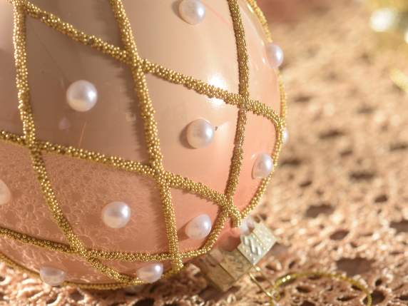 Glass ball with pearls and golden decorations in display of