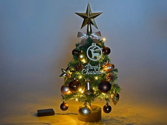 Christmas tree with decorations and LED lights on a wooden b