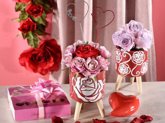 Cement vase on wooden tripod with rose decoration
