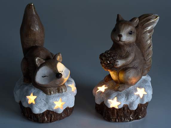 Terracotta fox and squirrel on a snowy trunk w-light