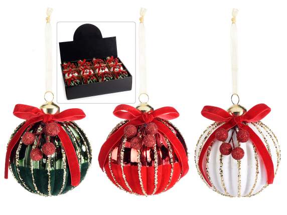 Hanging glass ball with decorations and bow on display
