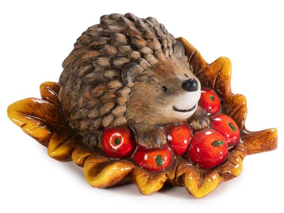 Hedgehog on leaf with berries in terracotta