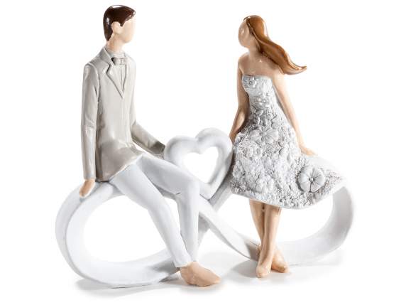 Resin couple sitting on infinity symbol with heart