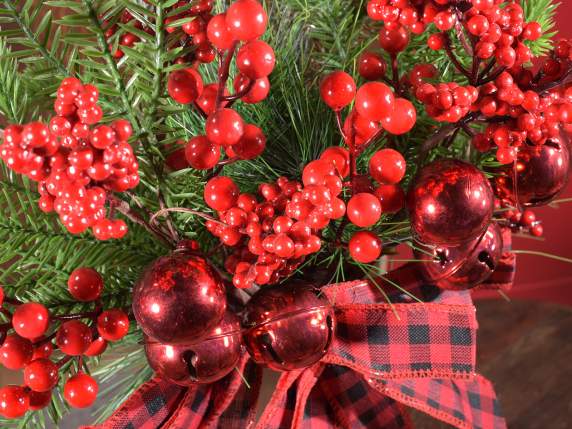 Pine branch with red berries, balls, bells and bow